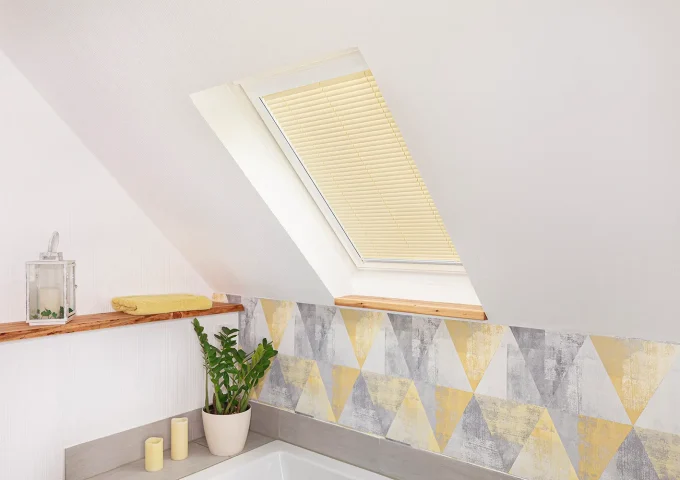 Schräg eingebautes Fenster in einem hellen Raum mit sanftem Lichteinfall.