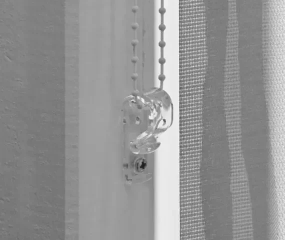 Nahaufnahme einer transparenten Halterung mit Kugelkette zur Bedienung eines Behangs