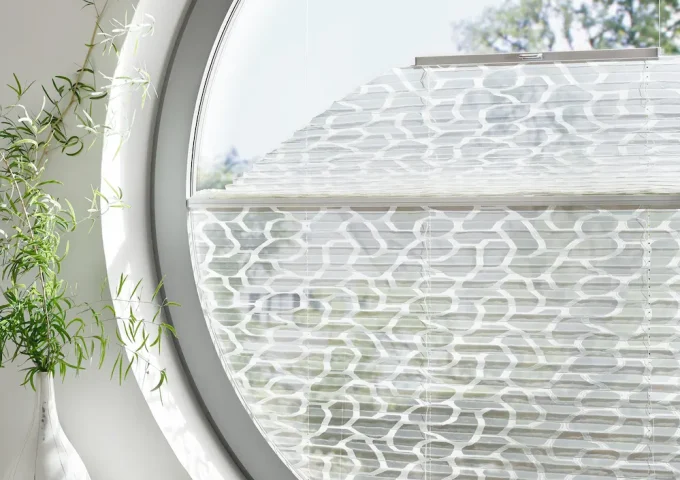 Rundes Fenster mit halbtransparentem Faltstoff in modernem Muster als Sicht und Sonnenschutz